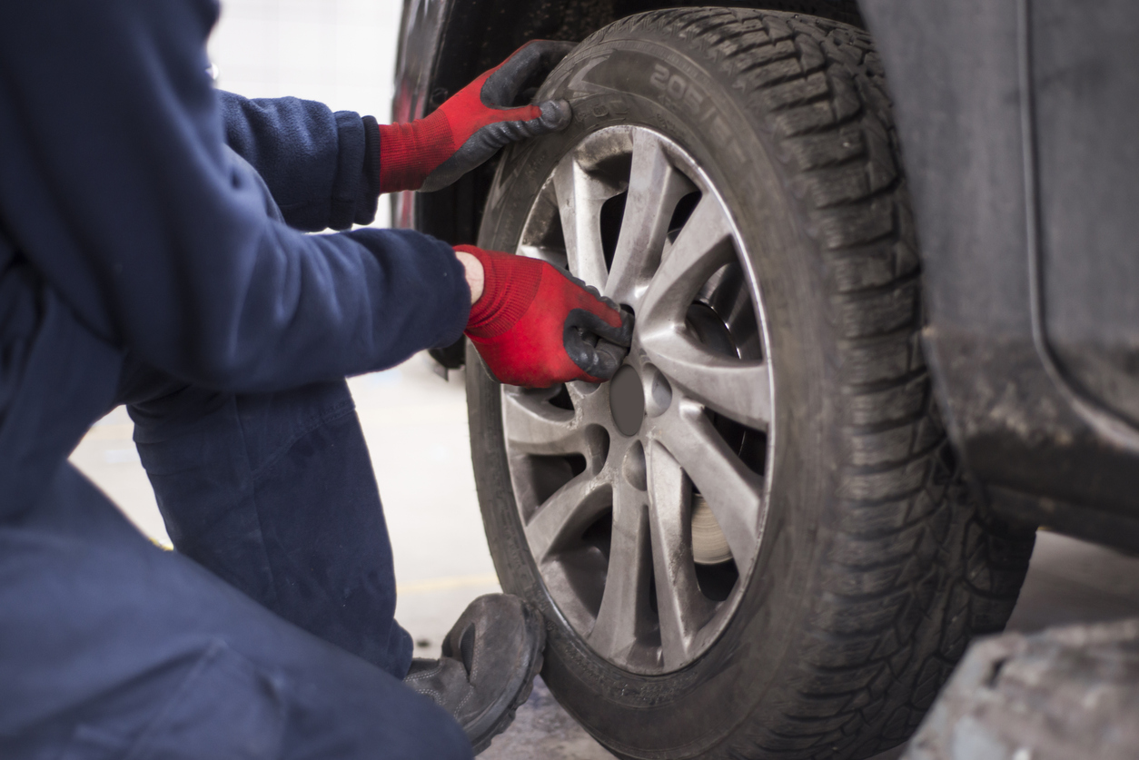 Tire repairman unscrewing the bolts on the rim of car wheel with Toyo Tires Tire Change in Mississauga